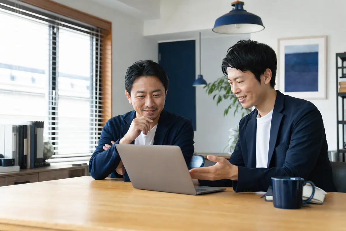 ホームページを見ながら打ち合わせをする経営者と制作担当者